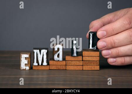 EMAIL. Marketing, advertising, communication and spam concept. Wooden alphabet letters on steps. Gray background Stock Photo