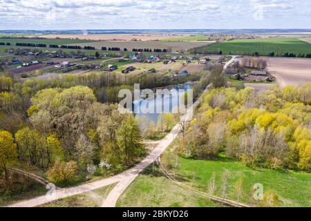 aerial view of a small rural village among green fields in sunny day. spring landscape of countryside Stock Photo