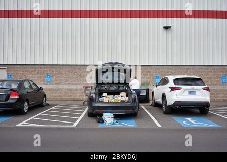 Shoppers load their car after shopping in a Costco warehouse store in Tigard, Oregon, during the coronavirus pandemic, on Tuesday, May 5, 2020. Stock Photo