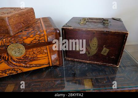 Closed antique mahjong set carrying case with a peacock and two game tiles on the cover or lid; engraved wooden crates, boxes, and chests. Stock Photo