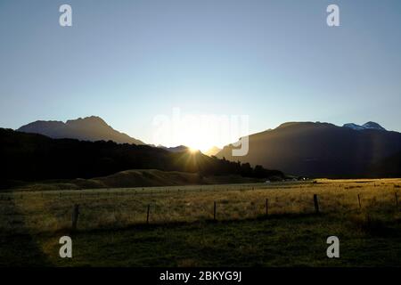 Sun setting behind the mountains. Paradise drive, Glenorchy. Stock Photo