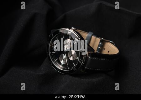 Watches - Luxury fashion watch with black dial and dark gray stitched watch leather, Vintage style wrist watch, Men's leather watch on the back backgr Stock Photo