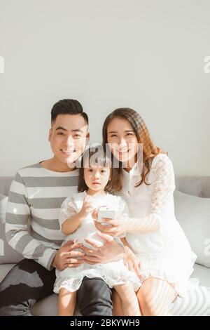 Happy family with children using mobile apps together at home Stock Photo