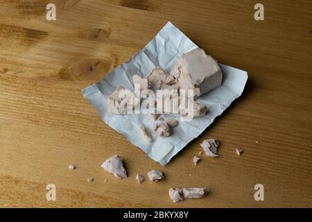 a cube of brewer's yeast crumbled on the table Stock Photo