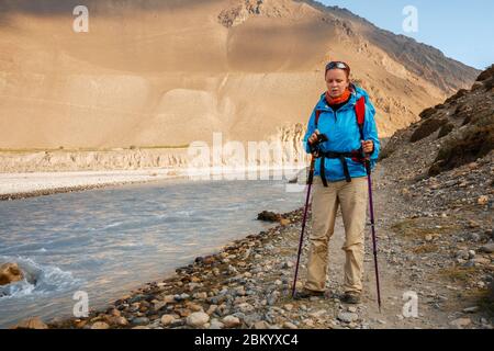 Trekking in the Himalayas. Tired young woman on trail along banks of the Kali Gandaki River, Lower Mustang, Nepal. Stock Photo