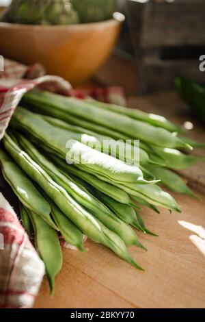 Still life of a bunch of string beans laid down on a wooden board in a rustic environment Stock Photo