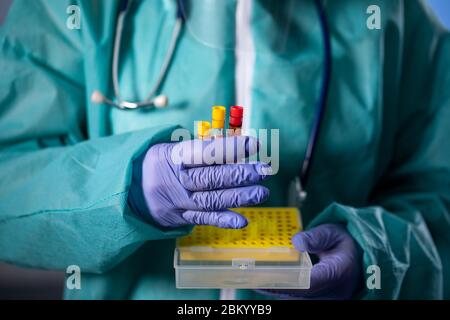 worker holding 2019-nCoV Coronavirus Test tube , COVID-19, Coronavirus epidemic disease with doctor or lab technician scientist in PPE Personal Protec Stock Photo