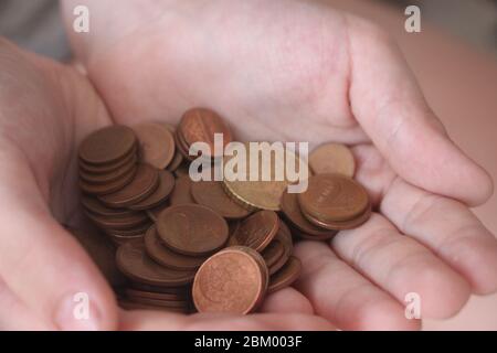 Two hands full of coins. Concept of savings or kid's pocket money Stock Photo
