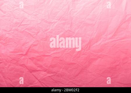 Texture of crumpled dark red wrapping paper with white gradient, closeup. Light pink and rose old vintage background. Material backdrop Stock Photo