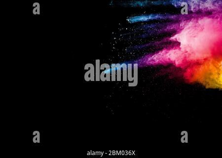 Abstract multi color powder explosion on black background.  Freeze motion of color dust  particles splash. Stock Photo