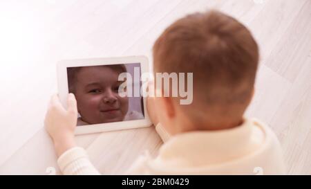 Cute boy. Face on screen. Light background. Horizontal Stock Photo