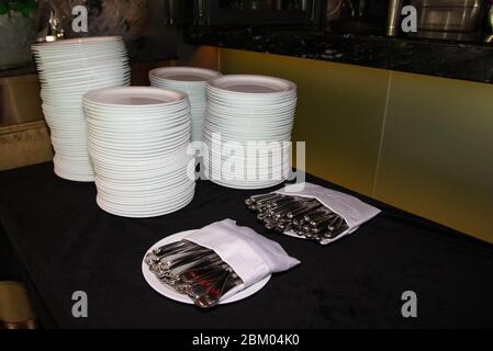 Stacked of plates,spoon,fork,knives on a buffet restaurant. Stock Photo