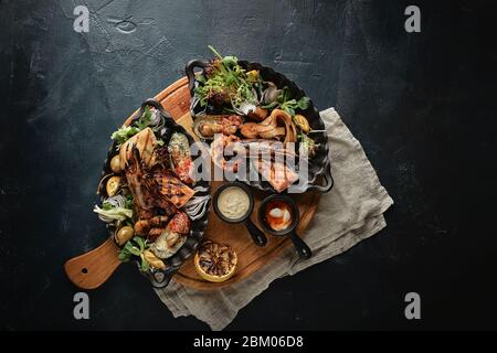 Assorted seafood, shrimp, scallops, squid, mussels. Serving plates on the table with a set of seafood. Classic italian food. Stock Photo