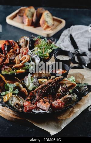 Assorted seafood, shrimp, scallops, squid, mussels. Serving plates on the table with a set of seafood. Classic italian food. Stock Photo