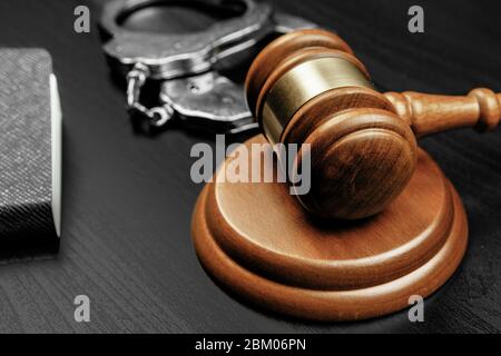 Judge gavel with handcuffs on wooden table Stock Photo