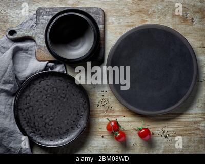 various empty dark plates on rustic wooden table, top view Stock Photo