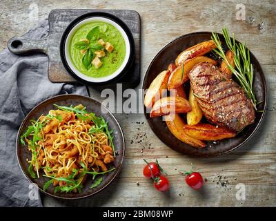 various dishes on the wooden kitchen dinner table, top view Stock Photo