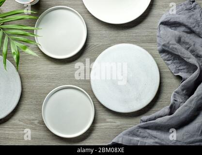 various empty white plates on grey wooden table, top view Stock Photo