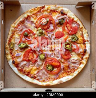 freshly baked pizza in cardboard box, top view Stock Photo