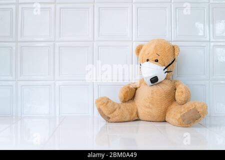 Teddy bear with face mask on white background. Concept of home school, isolation. Staying at home. Corona virus. Stock Photo