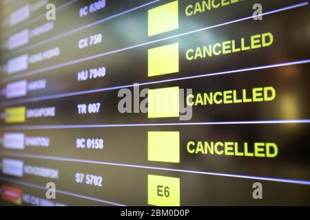 Flights cancelled and delayed on airport departure board due to covid-19 pandemic. Coronavirus causing disruption in air transport with airlines cance Stock Photo