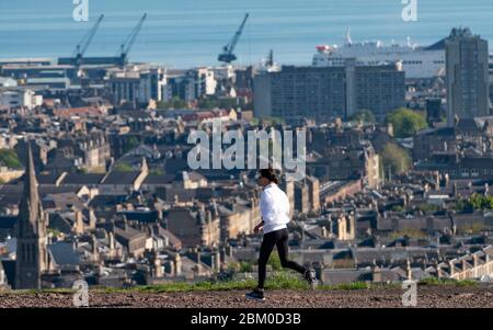 Edinburgh, Scotland, UK. 6 May 2020.  Unbroken sunshine and windless weather proved beautiful conditions for a female jogger taking daily exercise during the covid-19 lockdown on Calton Hill in Edinburgh today. The famous tourist destination was virtually deserted with only local joggers and dog walkers out enjoying the sunshine.  Iain Masterton/Alamy Live News