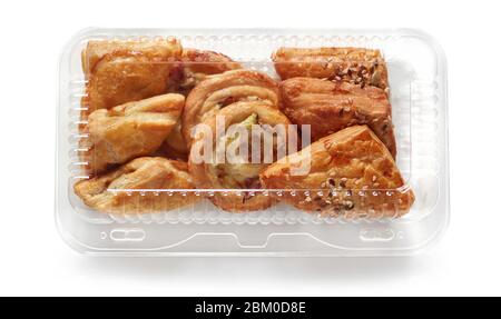 freshly baked bread buns in transparent plastic box isolated on white background Stock Photo
