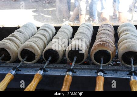 Kurtos kalacs or chimney cakes, preparing cooking on charcoal grill, street food traditional Hungarian, during food festival. Kurtos Kalacs traditiona Stock Photo