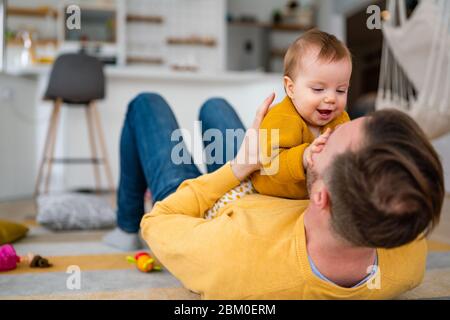 Happy young father playing with little daughter at home Stock Photo