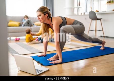 Young woman is exercising yoga at home. Fitness, workout, healthy living and diet concept. Stock Photo