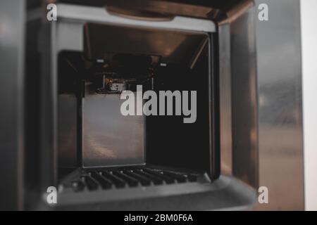 Dirty coffee machine close up look. Barista equipment. Coffee maker pouring hot espresso coffee . Selling coffee machine at petrol station Stock Photo