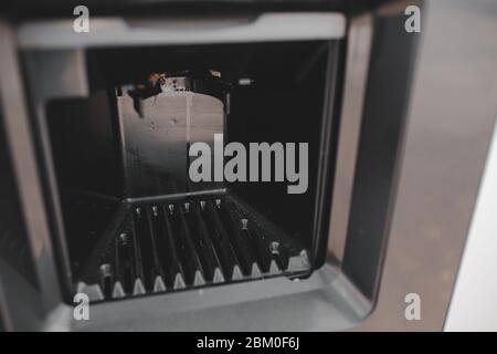 Dirty coffee machine close up look. Barista equipment. Coffee maker pouring hot espresso coffee . Selling coffee machine at petrol station Stock Photo