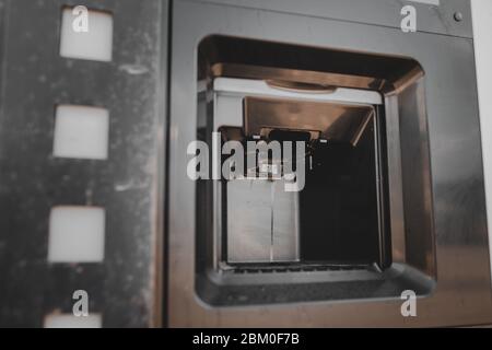 Dirty coffee machine close up look. Barista equipment. Coffee maker pouring hot espresso coffee . Selling coffee machine at petrol station Stock Photo