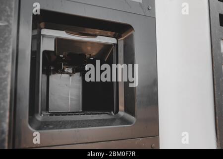 Dirty coffee machine close up look. Barista equipment. Coffee maker pouring hot espresso coffee . Selling coffee machine at petrol station Stock Photo