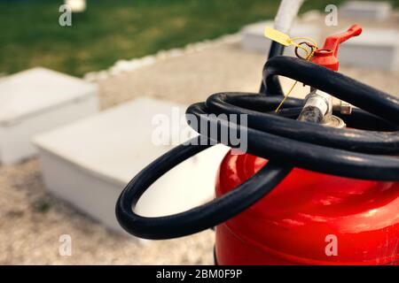 Fire close-up extinguishers available in fire emergencies at a petrol station background. Stock Photo