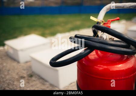 Fire close-up extinguishers available in fire emergencies at a petrol station background. Stock Photo
