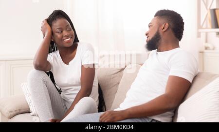 Afro husband and wife chatting together in living room at home Stock Photo