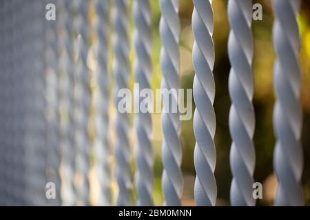 Spiral rods of a fence with a blurry background Stock Photo