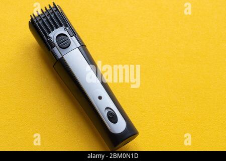 Shaver on a yellow background. The concept of a shaving machine. Stock Photo
