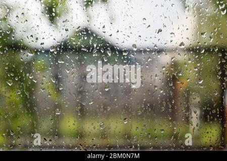 Raindrops on the window pane. Blurred background outside the window in the rain. Stock Photo