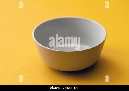 Empty white Cup on a yellow background, isolate. Stock Photo