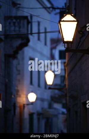 Old fashioned street lamps in the street in the twilight Stock Photo