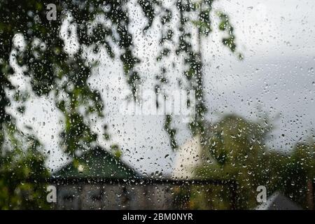 Raindrops on the window pane. Blurred background outside the window in the rain. Stock Photo