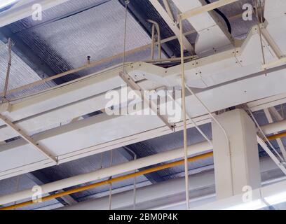 Ceiling mounted Lamp pipes and air ducts and communication system in the hall Stock Photo