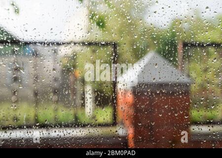 Raindrops on the window pane. Blurred background outside the window in the rain. Stock Photo