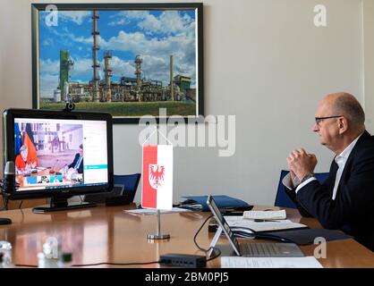 Potsdam, Germany. 06th May, 2020. Dietmar Woidke (SPD), Prime Minister of Brandenburg, is listening to the speech of Chancellor Angela Merkel (CDU) on the computer monitor in the State Chancellery during the Federal-Länder Conference. Credit: Soeren Stache/dpa/Alamy Live News Stock Photo