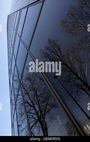 Glass mirror skyscraper wall with blue sky and white clouds reflection ...