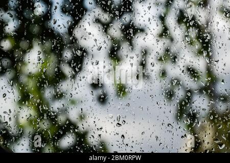 Raindrops on the window pane. Blurred background outside the window in the rain. Stock Photo