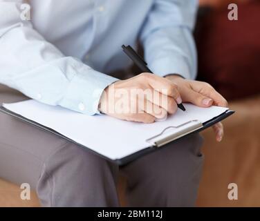 Unrecognizable Professional Psychologist Taking Notes Sitting On Couch In Office Stock Photo