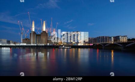 Exterior view across the River Thames at night. Circus West Village - Battersea Power Station, London, United Kingdom. Architect: simpsonhaugh, 2018. Stock Photo